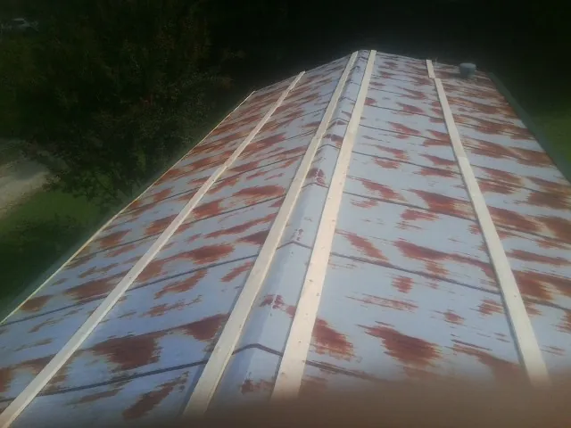 Rusted metal roof panels with new wood purlins before replacement — Storm Damage Roof Repair in Bremen by Roofing Brothers